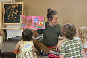 A parent reading a book to children