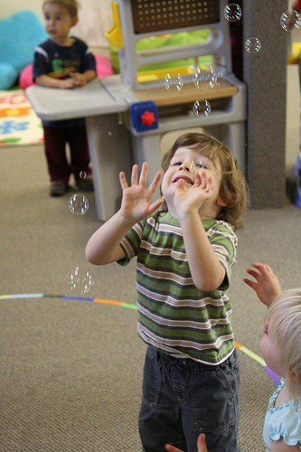 Children playing with bubbles. Has nothing to do with the building location other than to entice you.